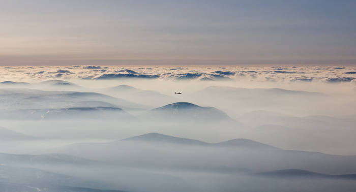 Glider wave soaring above mist